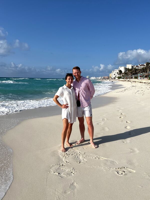 Mitchell and Kathleen smiling together on a sunny trip to Cancun