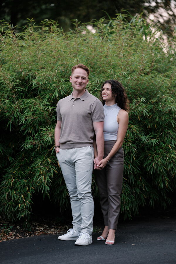 Mitchell and Kathleen posing beside a flowering bush