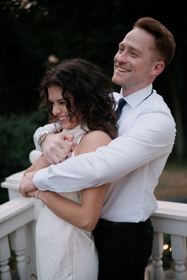 Mitchell and Kathleen standing together on a patio at sunset