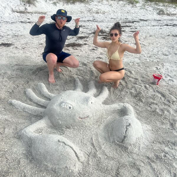 Mitchell and Kathleen with sand sculptures on the beach